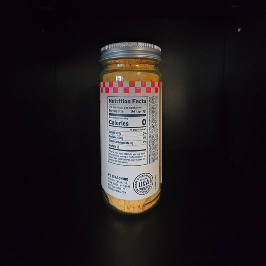 A glass jar filled with yellow-orange powder, featuring a white label with red checkered accents and a silver metal lid, set against a solid black background.