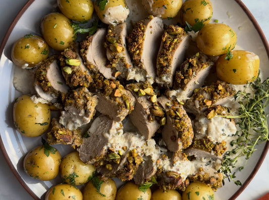 Pistachio crusted pork tenderloin on plate with potatoes