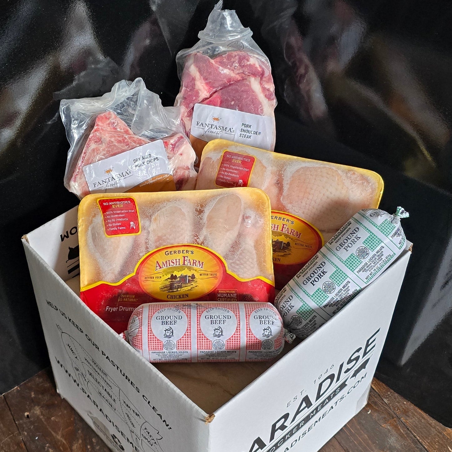 Variety of packaged meats packed a box stacked on cardboard