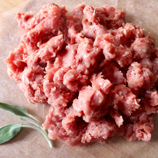 Ground Chicken on cutboard background with sage leaves