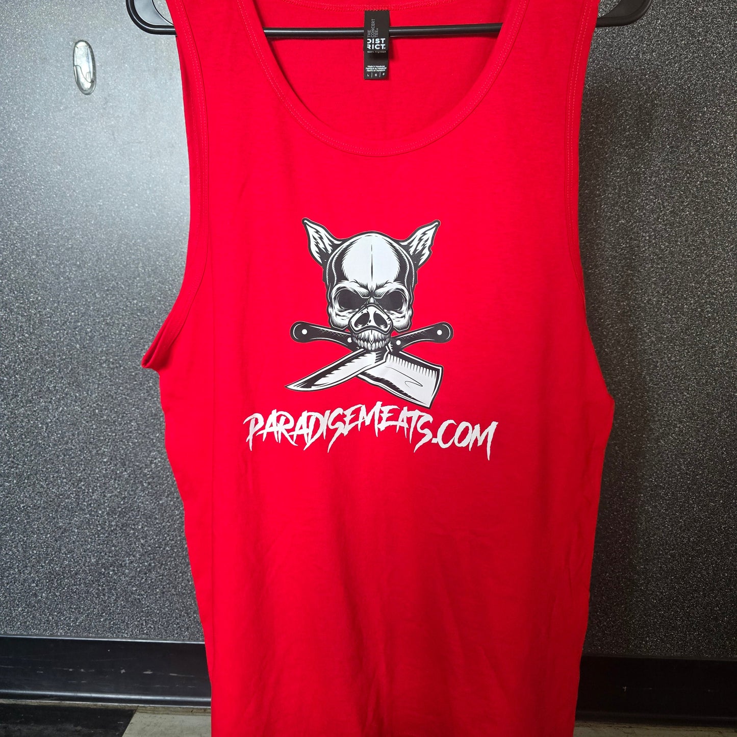 A red sleeveless tank top laid flat on a hanger, featuring a white skull and crossed knives graphic with the text 'PARDYSWAGERS.COM' printed in white on the front.