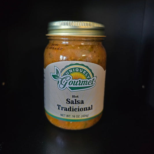 A jar of Unique Gourmet Hot Salsa Tradicional with a white label and gold lid, set against a dark background.