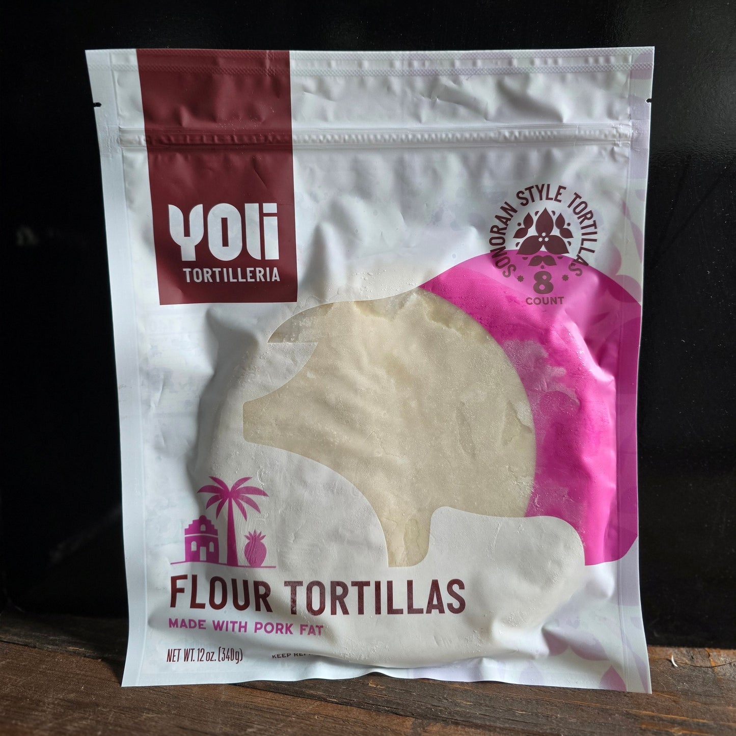 Yoti Tortilleria flour tortillas packaging on a wooden surface with a dark background