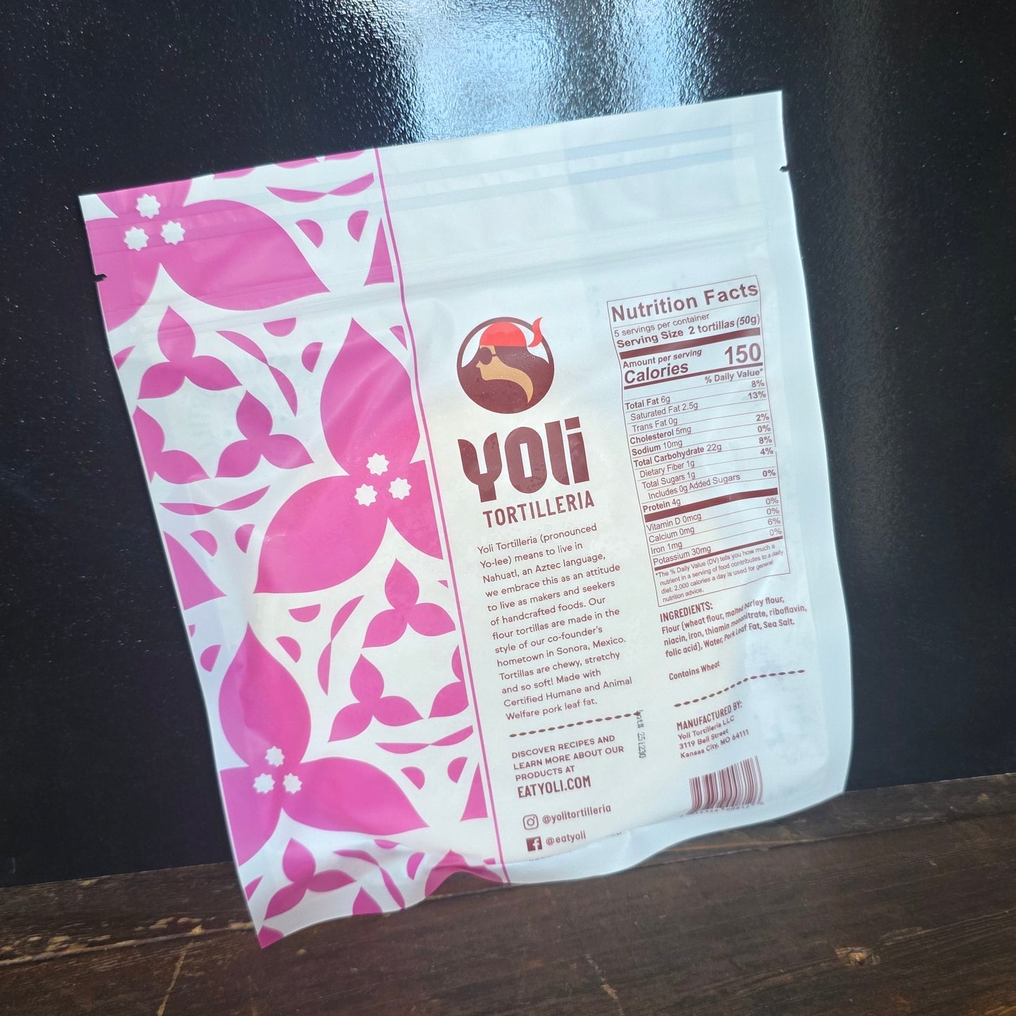 Yoli tortilla package with pink and white nutritional information on a dark surface