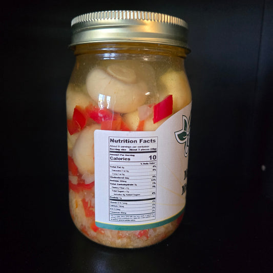 A glass jar filled with sliced white onions and red bell peppers in a light sauce, sealed with a gold metal lid and featuring a white label with a Nutrition Facts panel, set against a dark background.