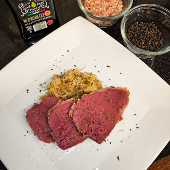 Sliced and plated Corned Beef Tri Trip on a bed of cabbage